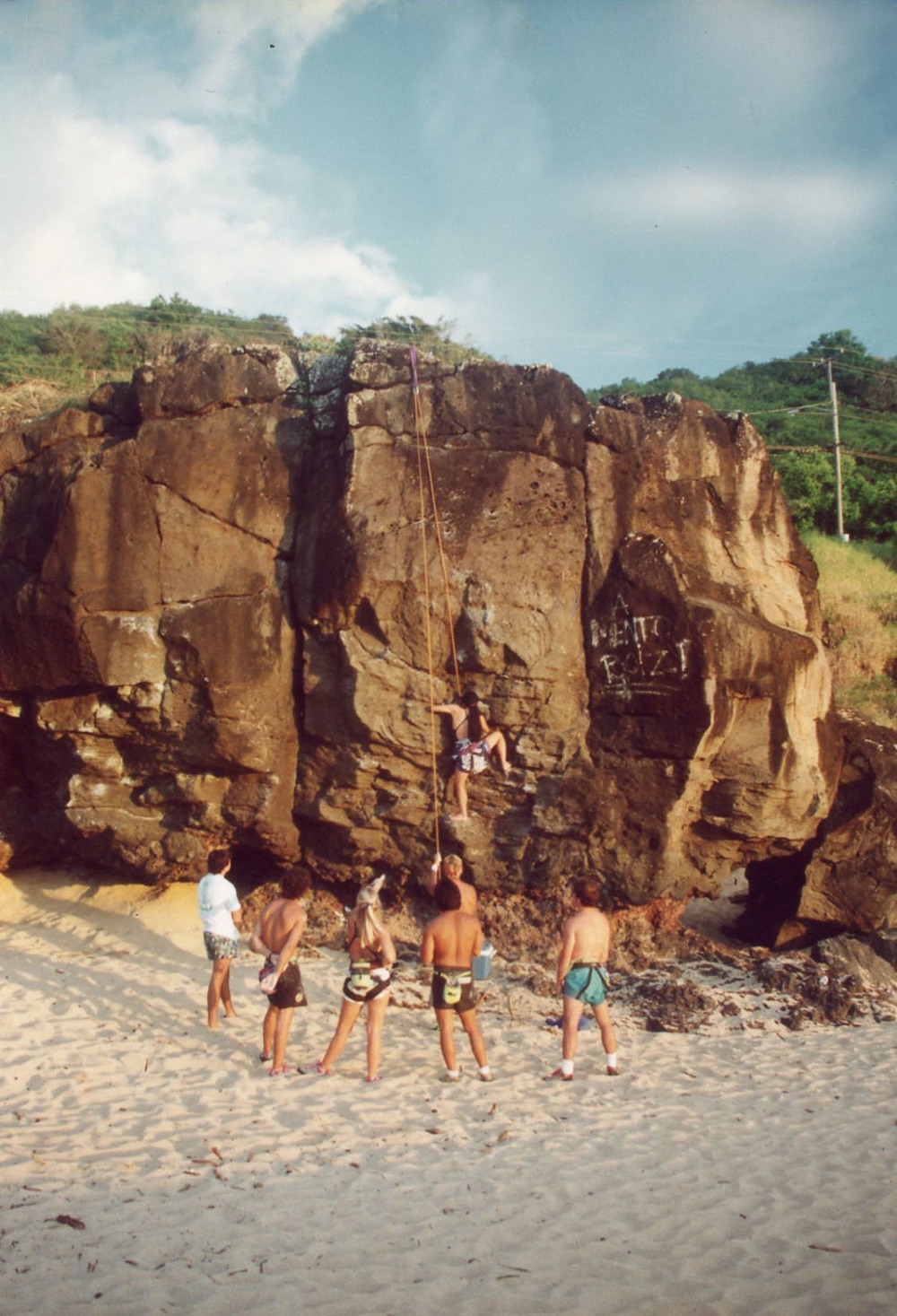 Film photo of a group of rock climbers top-roping in Waimea Bay, Hawaii