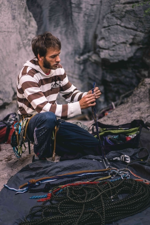 Una guida di arrampicata su roccia che si prepara a scalare una delle torri di arenaria nella Repubblica Ceca