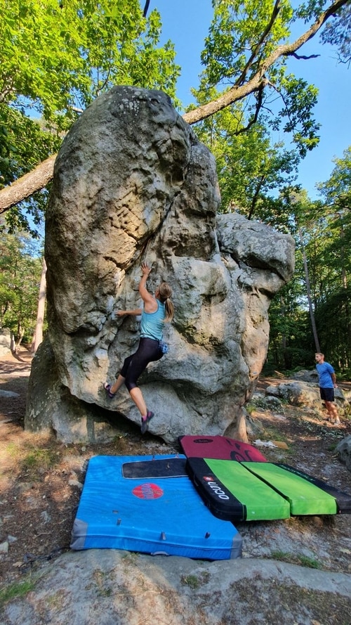 A climber trying a boulder in Mont Ussy