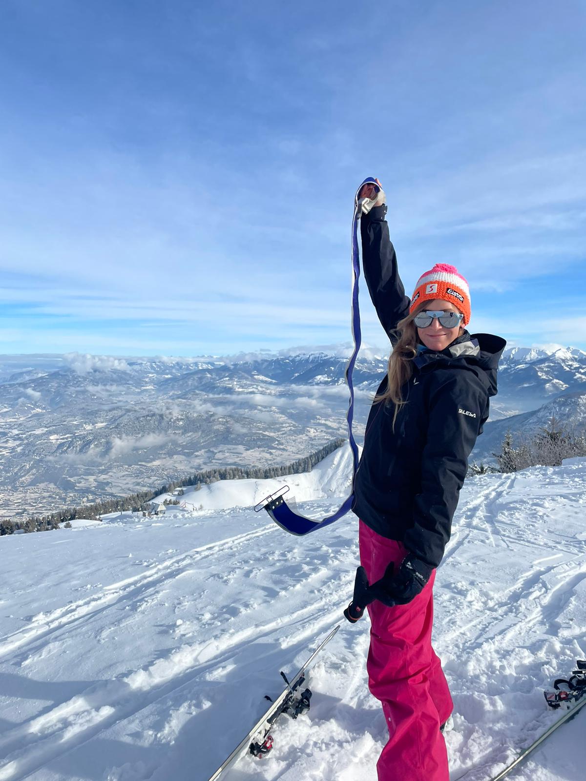 Alessia  putting skins on her skiis while ski touring