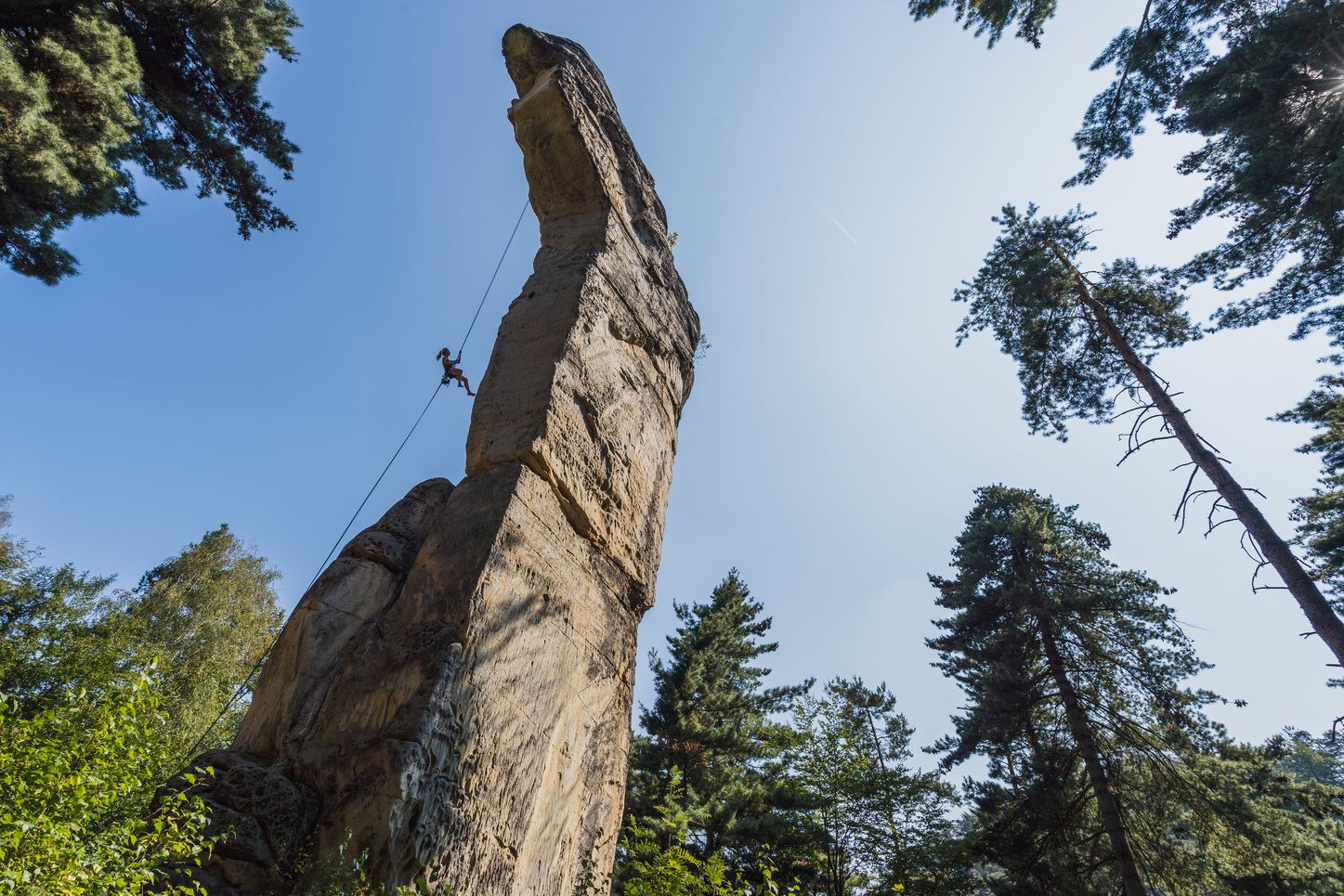 A climber abseiling off a multipitch sandstone tower in the Czech  Republic