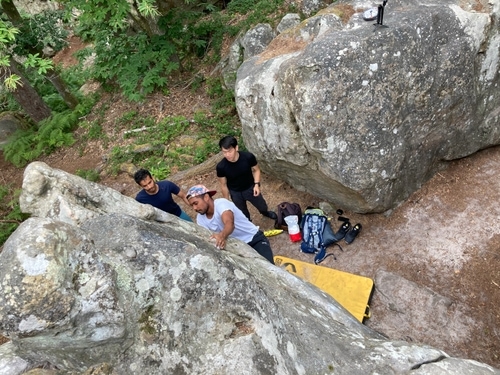 A climber topping out a boulder in Fontainebleau