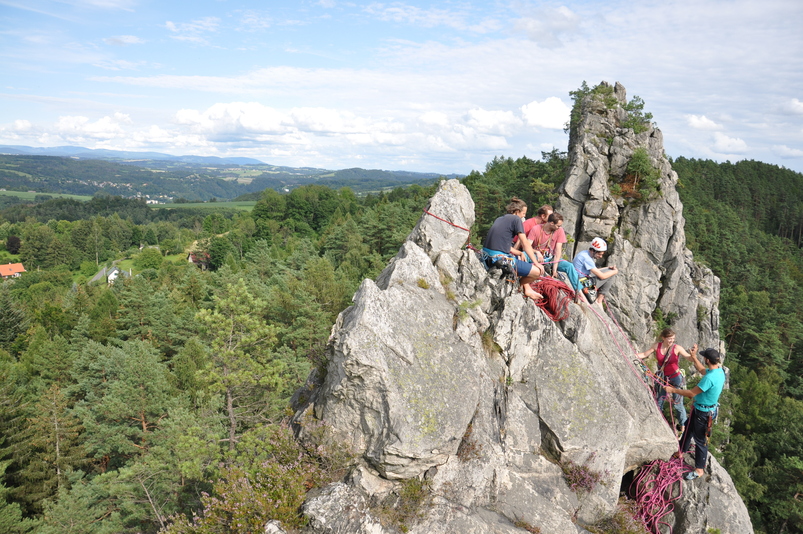 A climbing being high fived after summitting one of the Czech sandstone towers