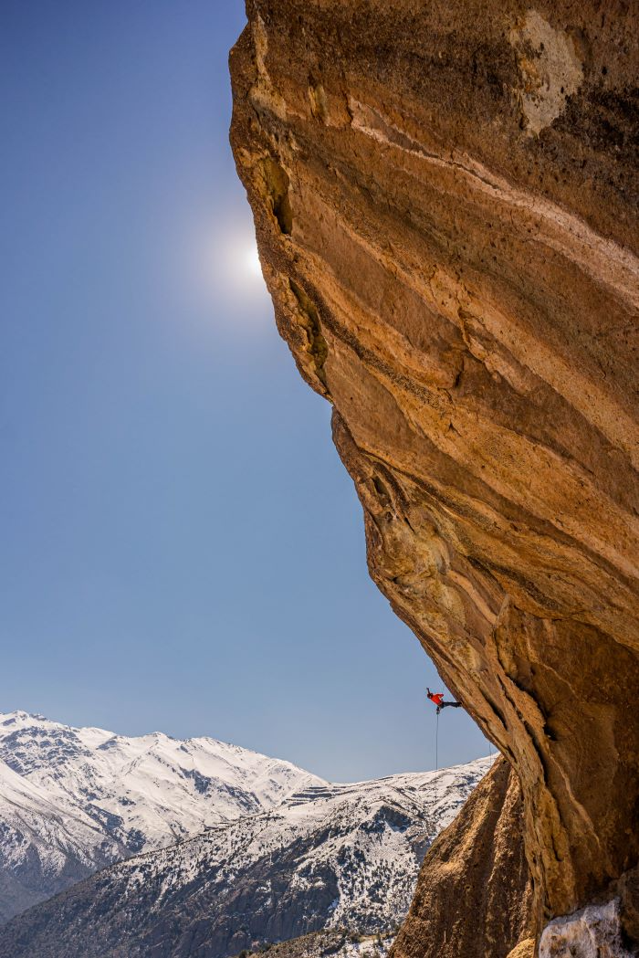 A climber rappelling off a multi pitch in Cajon el Majpo, Chile