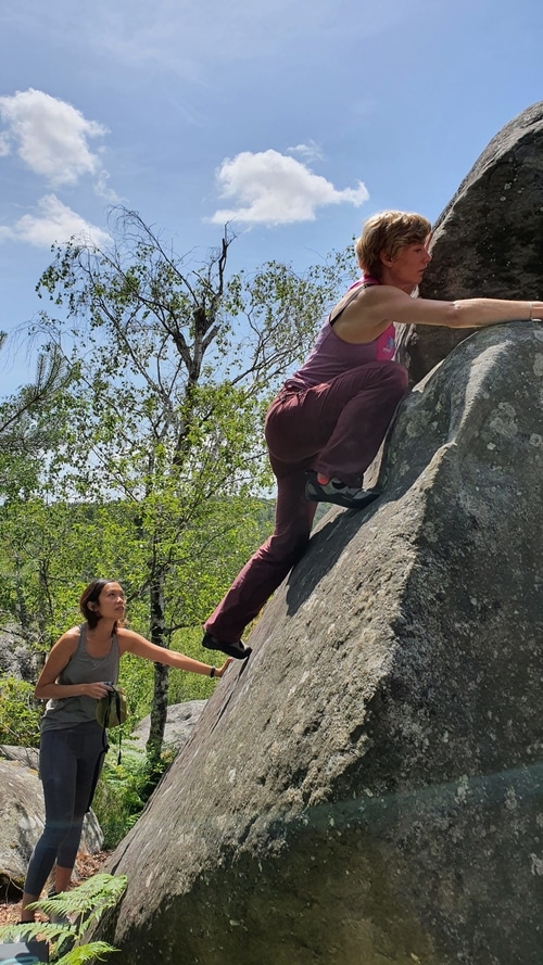 A person topping out on a boulder in Gorges D'Apremont