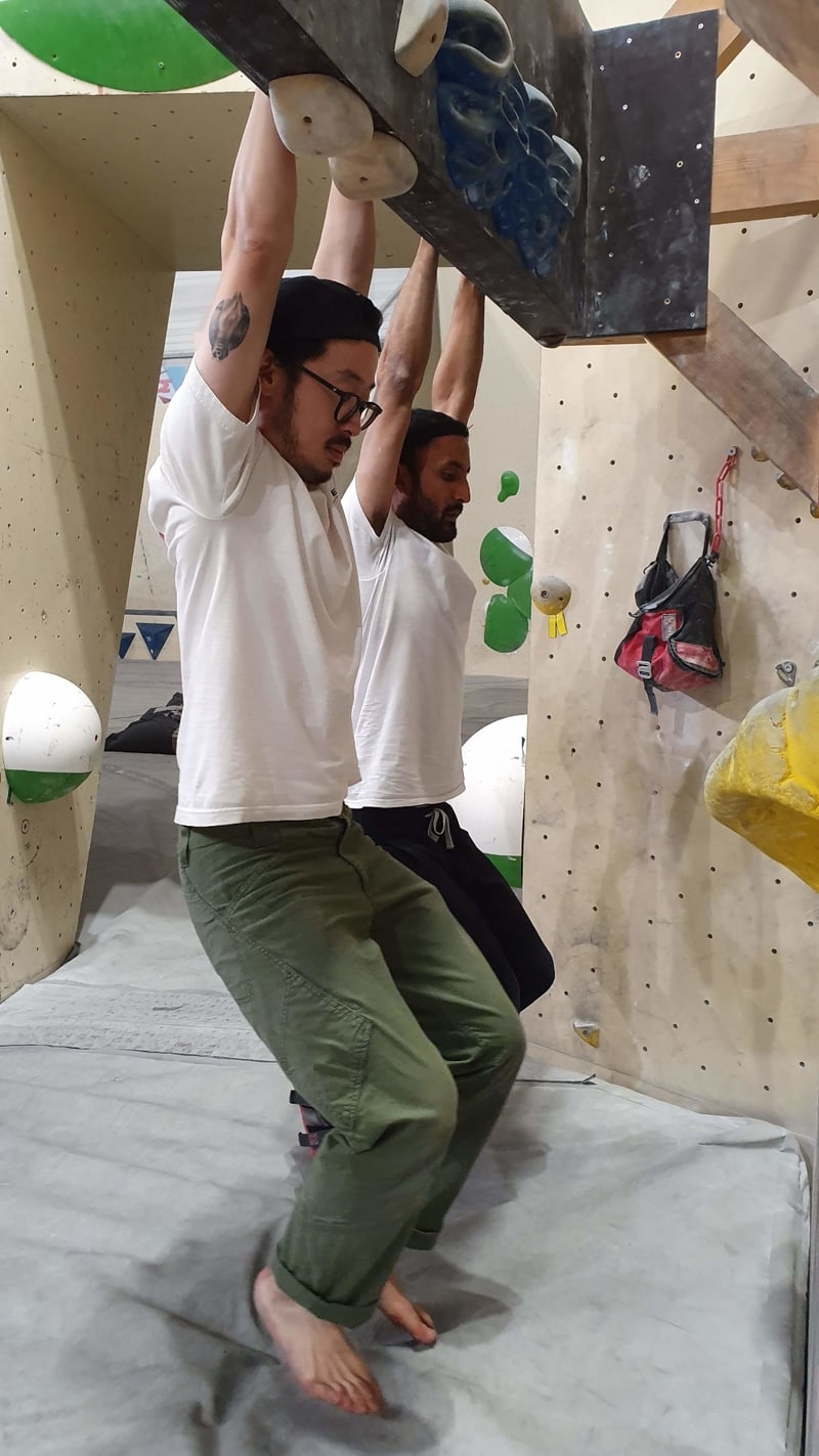 Climbers hangboarding at the gym