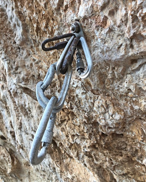 A close up of a rusted anchor on a sport climb
