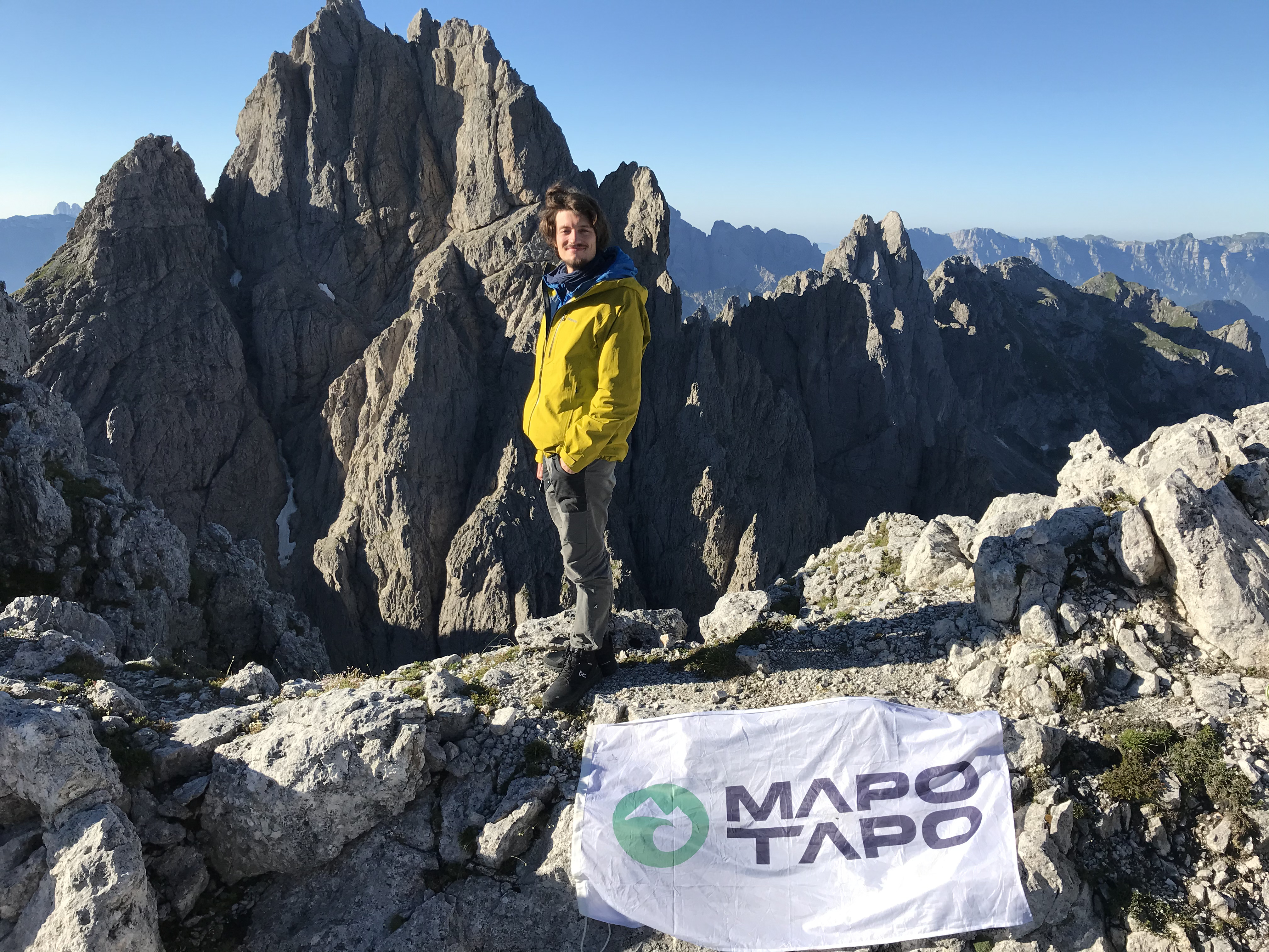Mapo Tapo CEO in piedi davanti ad alcune cime delle Dolomiti