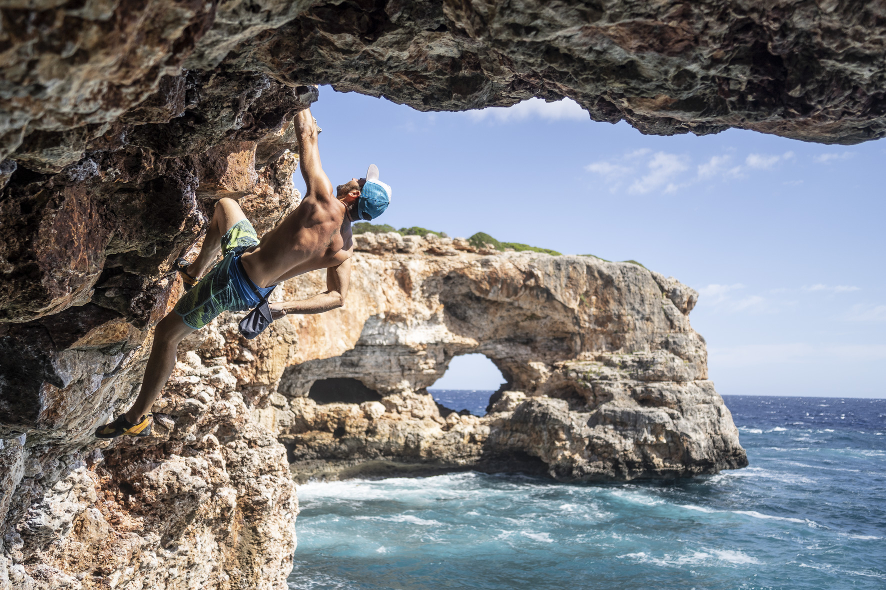 Seba, a 2022 Share for Bolts contestant on a cliff by the sea in Mallorca