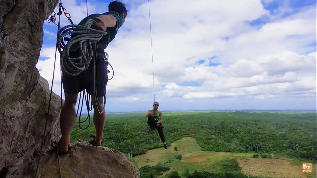 Un'assicuratrice lancia la corda a un arrampicatore a Vinales, Cuba