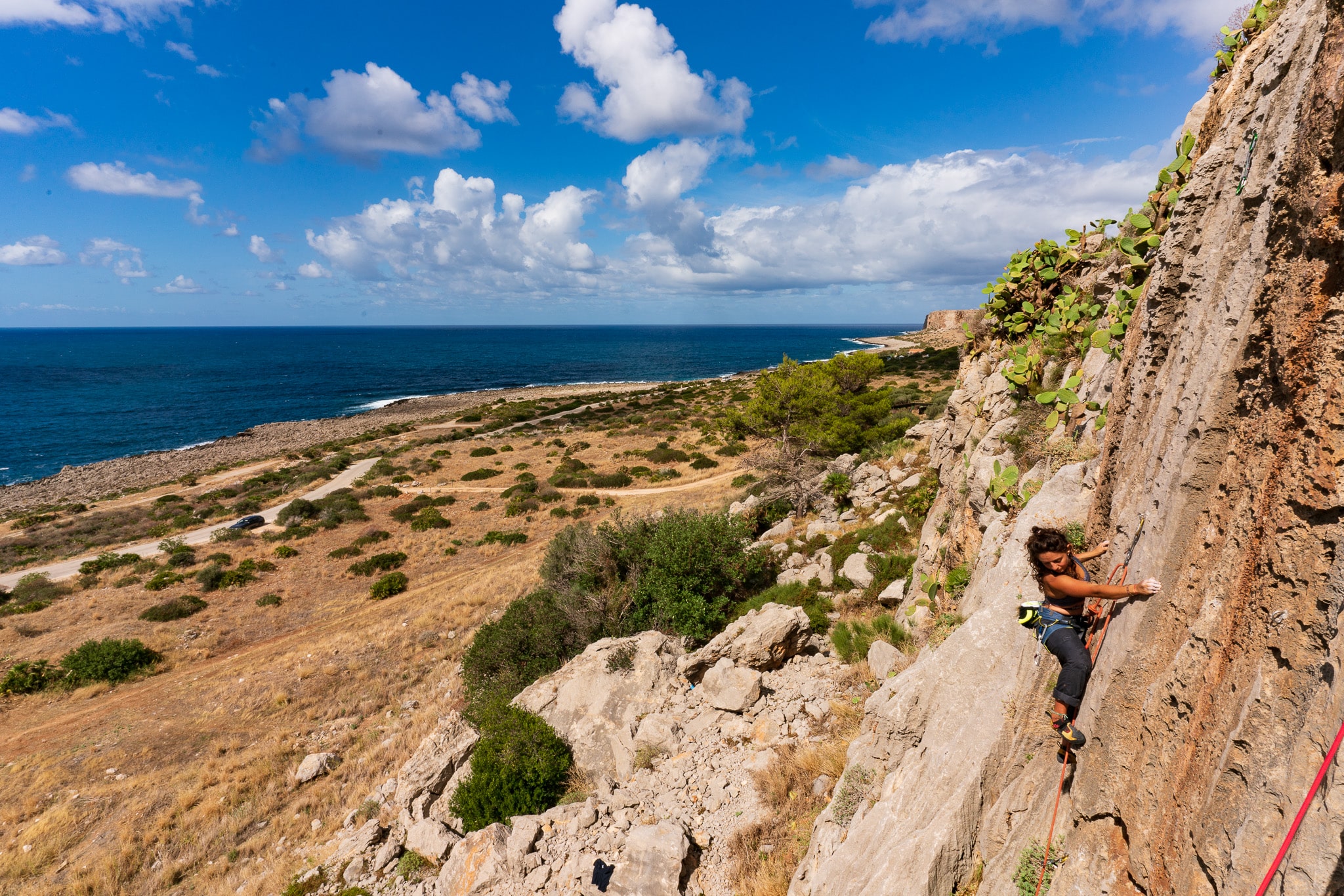 A person sport climbing on the Salinella Cliff near San Vito Lo Capo