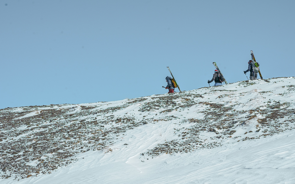 Three ski mountaineers hiking across a ridge
