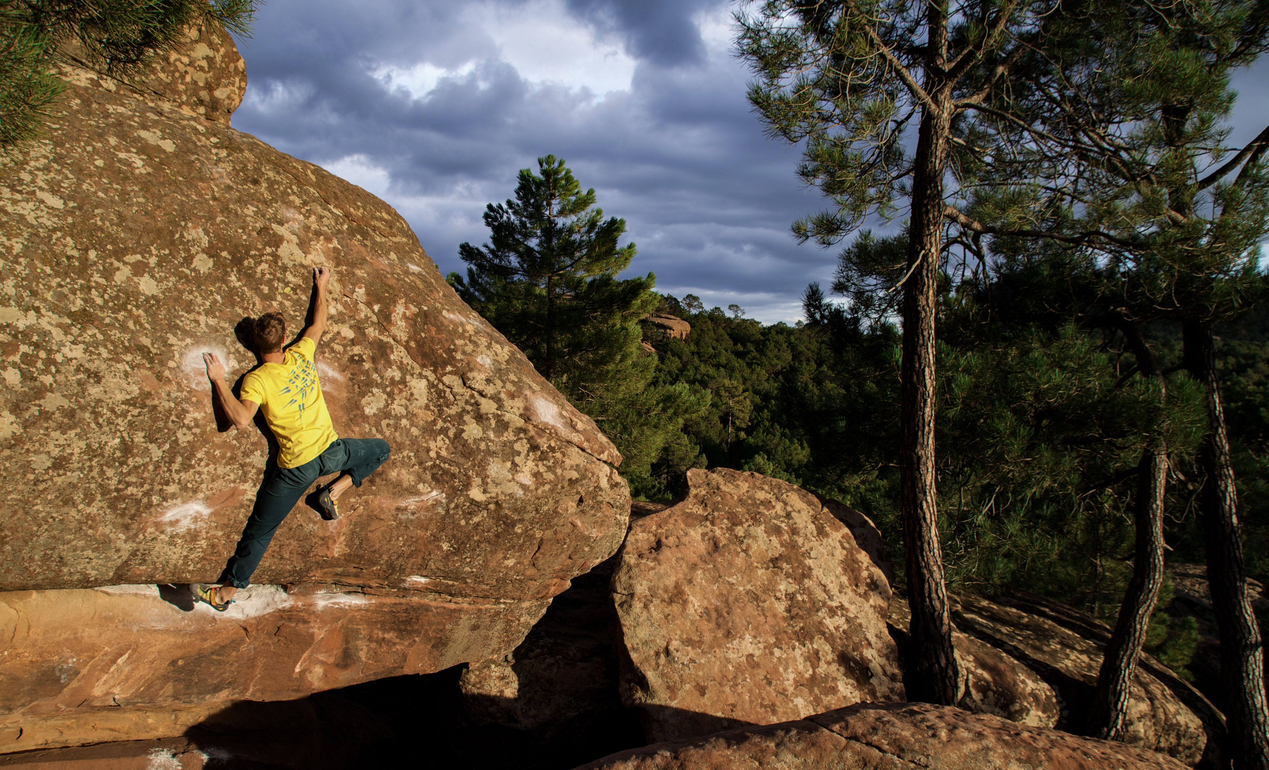 A person in a yellow t-shirt bouldering in Albarracin