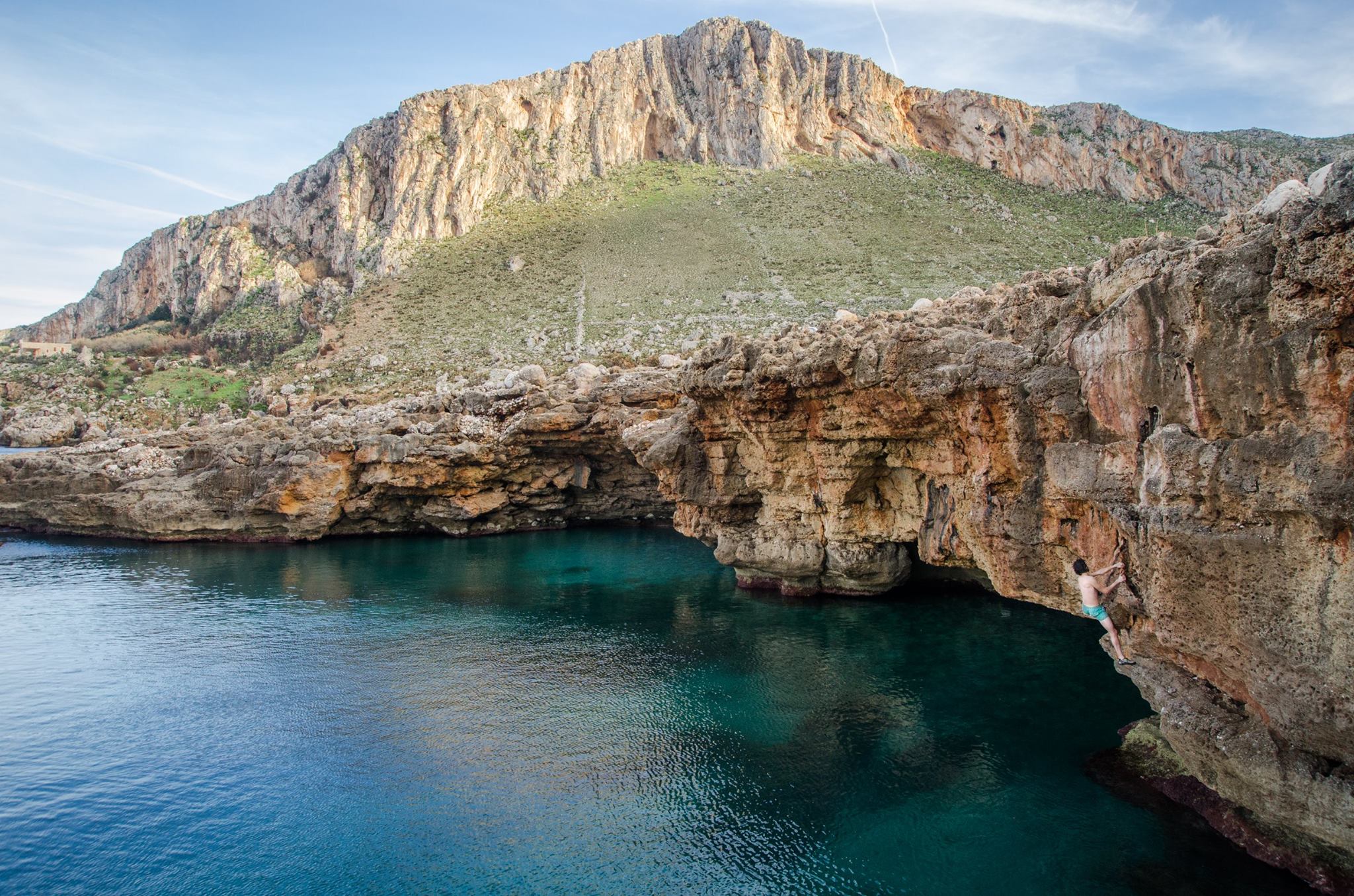 A climber deep water soloing in Western Sicily