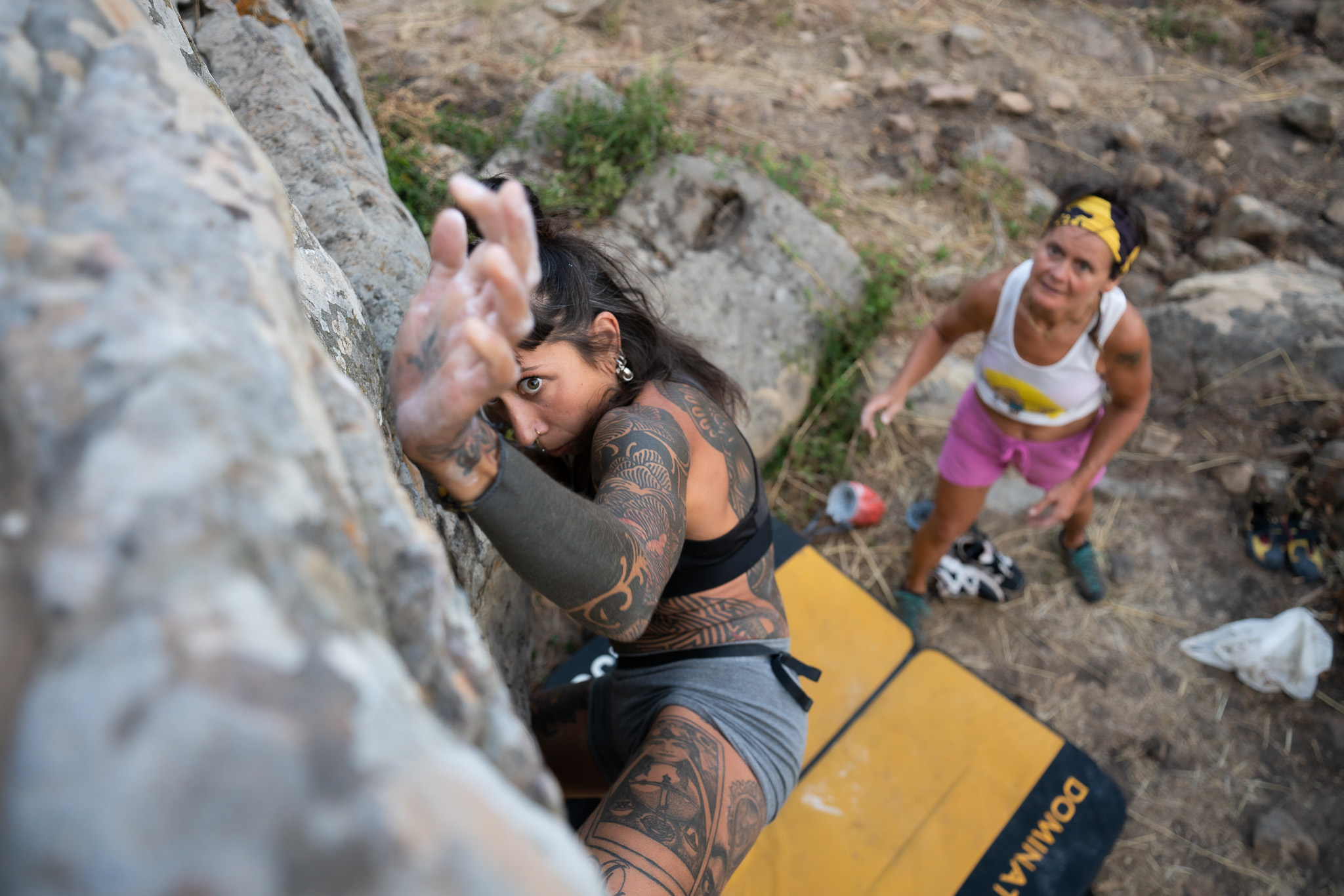 A person bouldering with a spotter