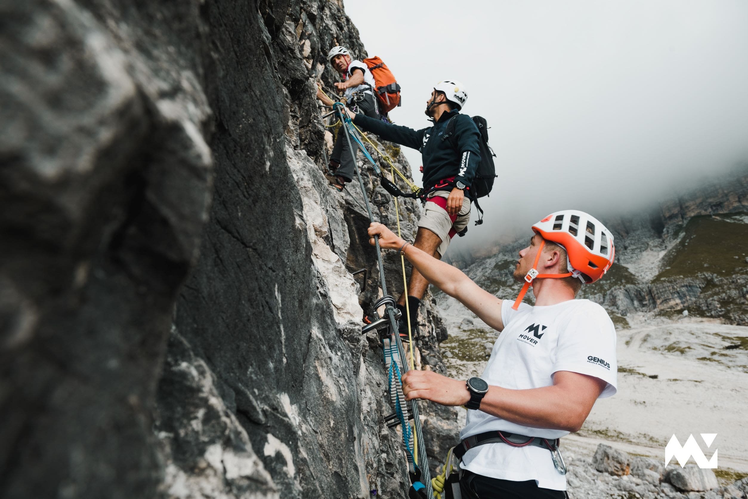 Three people climbing a via ferrata in the Dolomites