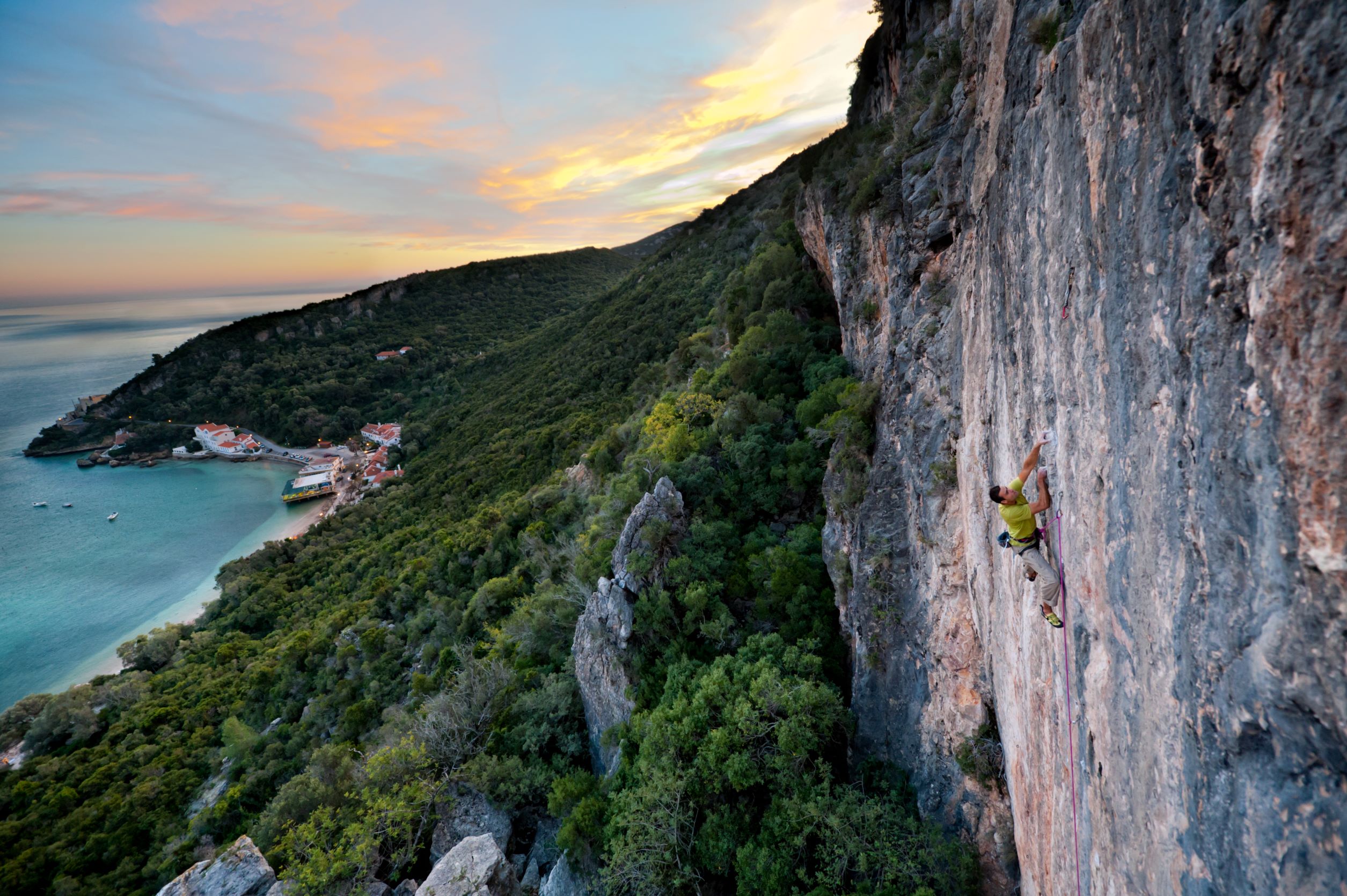 Uno scalatore su una scogliera calcarea vicino a Lisbona, Portogallo