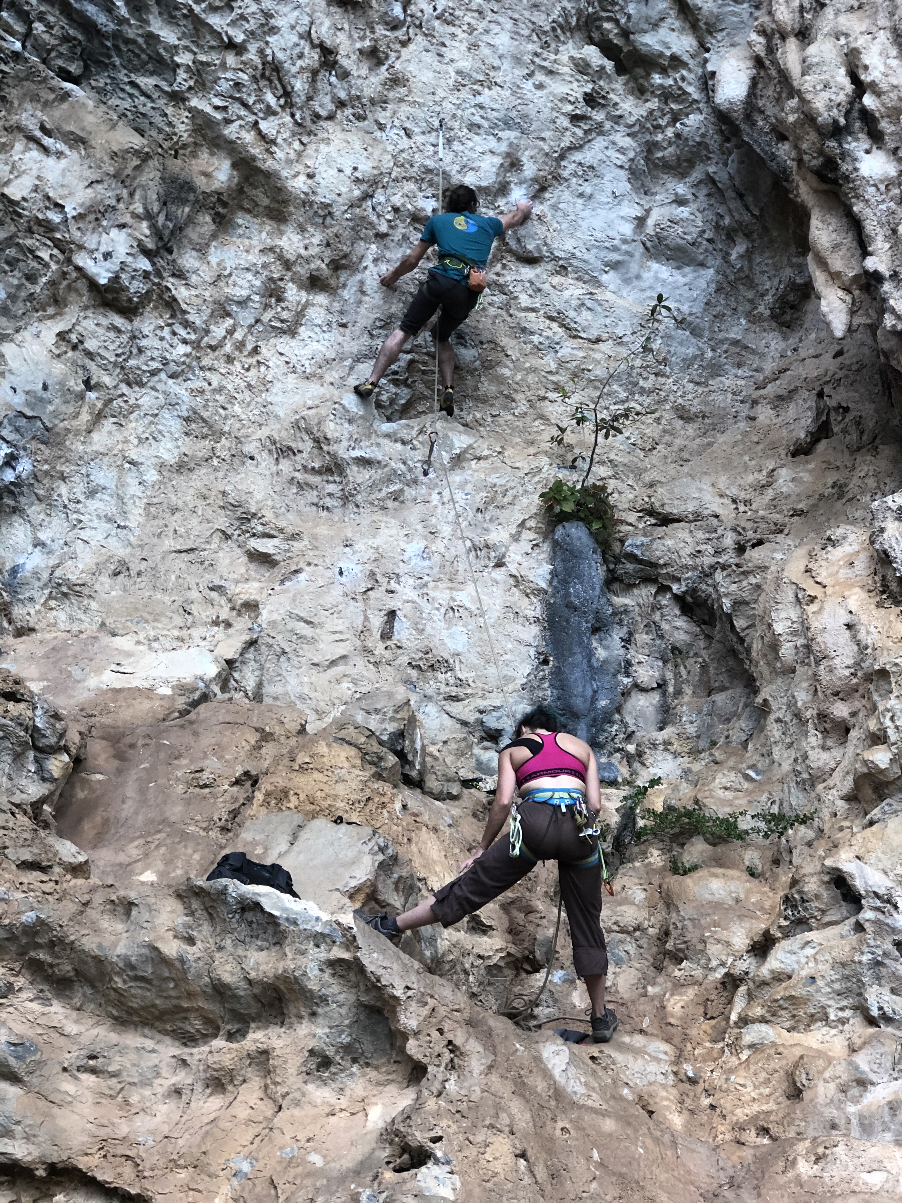 A female belaying a male climber in Vinales, Cuba