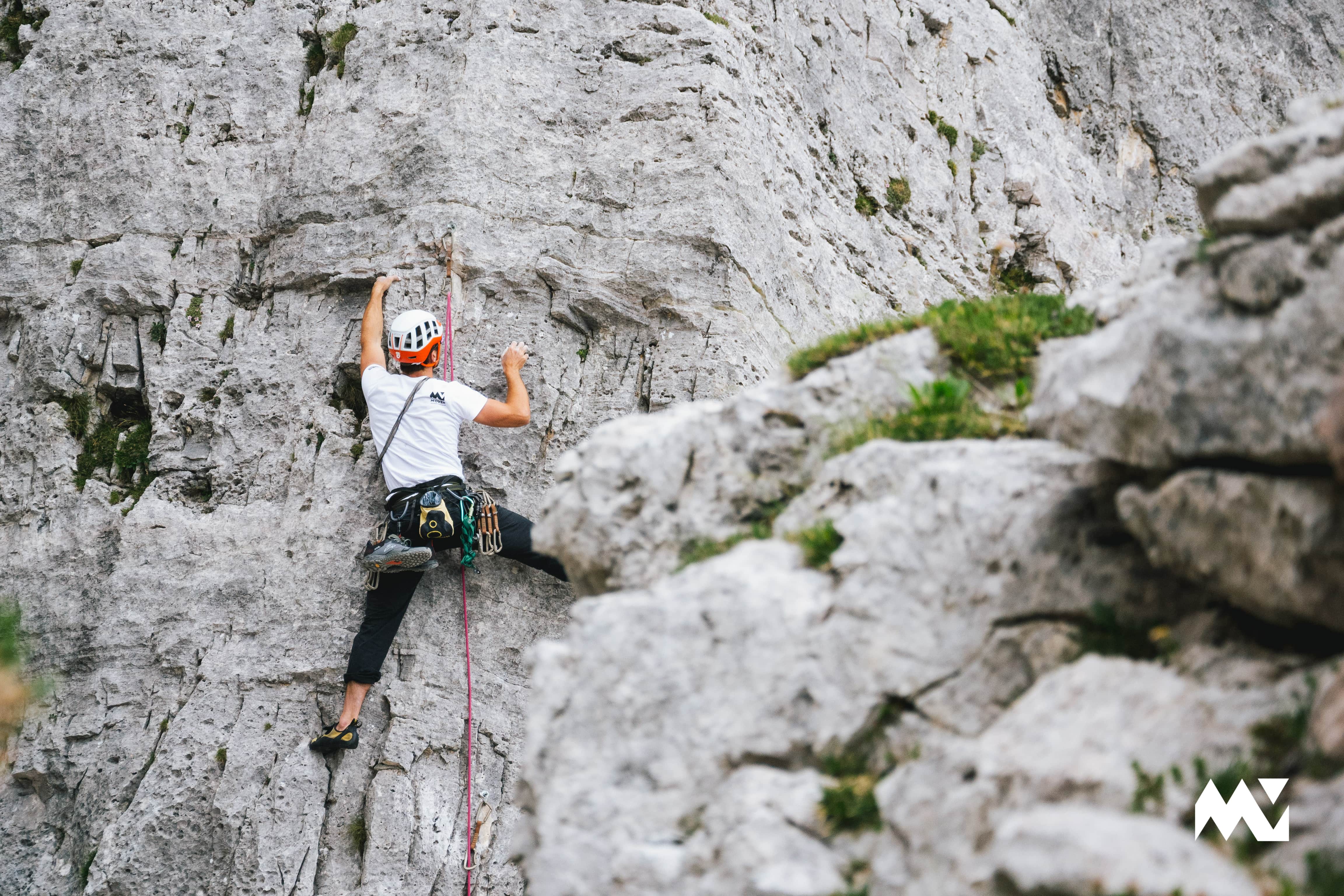 Close up shot of a person lead climbing a slab in the Ampezzo valley